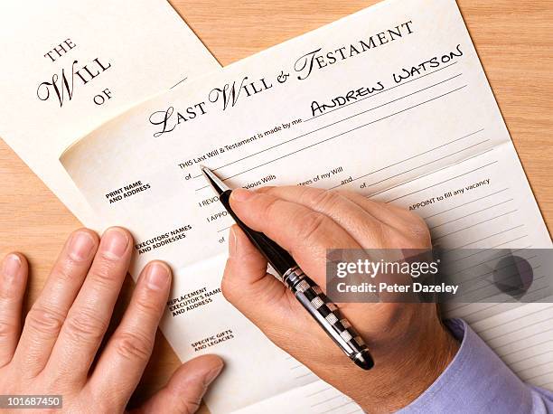 mature man writing his will - erfenis stockfoto's en -beelden