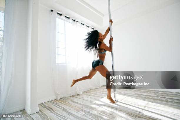 woman exercising on pole - pole dance stock pictures, royalty-free photos & images