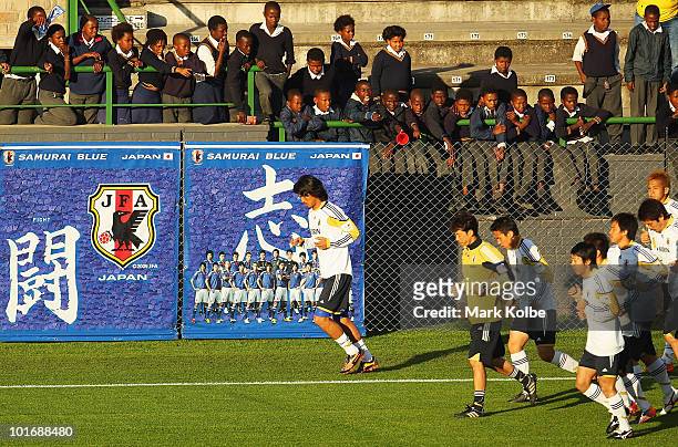 Local children cheer the Japan team as they run a lap at Outeniqua Stadium on June 7, 2010 in George, South Africa.