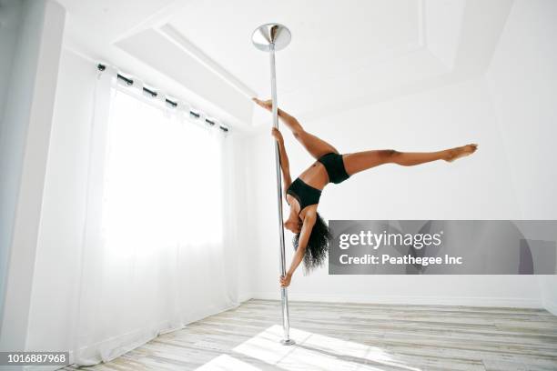 woman exercising on pole - pole dance fotografías e imágenes de stock