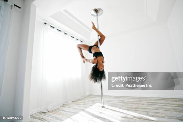 woman exercising on pole - pole dance fotografías e imágenes de stock