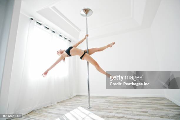 woman exercising on pole - stangentänzerin stock-fotos und bilder