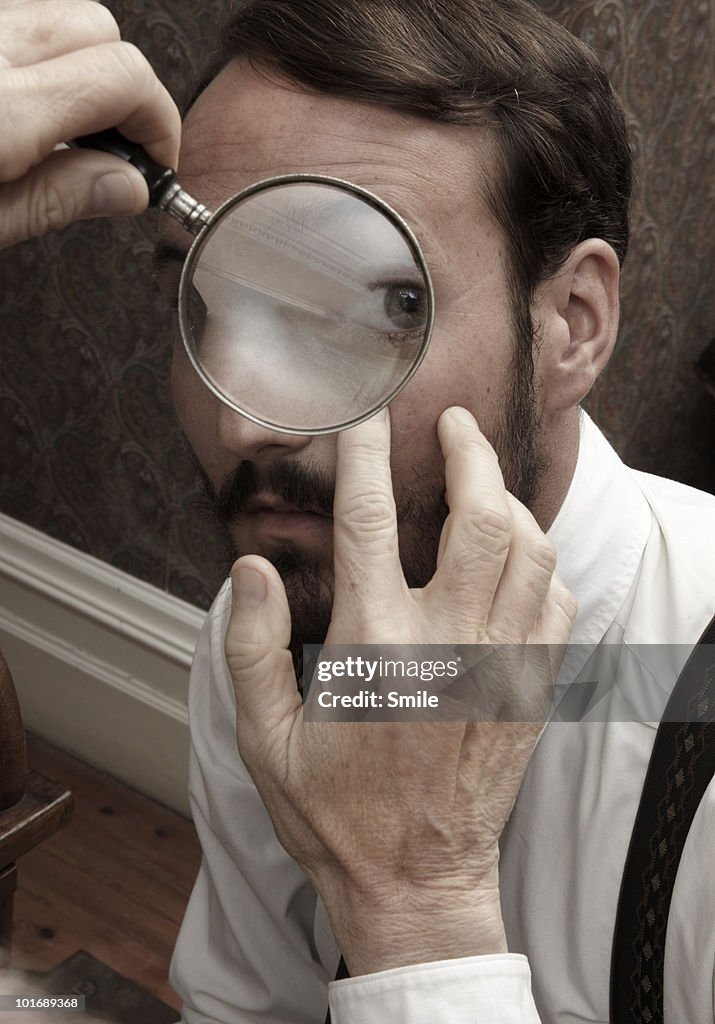 Man's eye being examined with a magnifying-glass