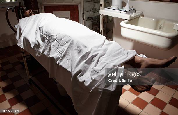 man lying on operating table in antiquated theatre - depósito de cadáveres fotografías e imágenes de stock