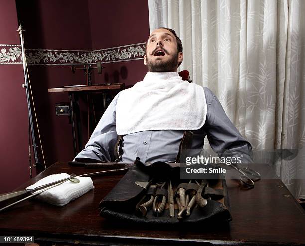 nervous man in dentist chair - baby bib stock pictures, royalty-free photos & images