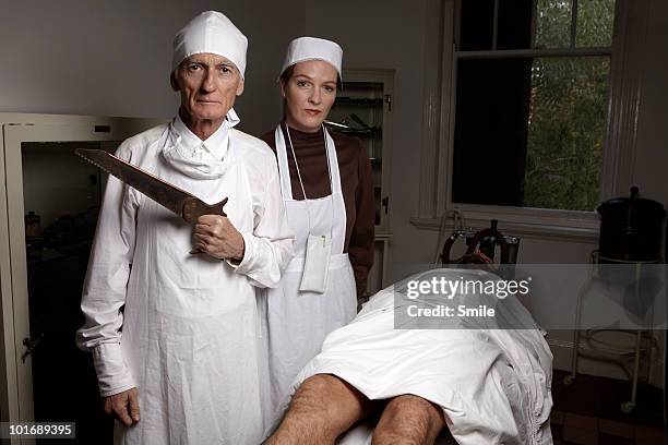 surgeon with saw, antiquated theatre  - operating table stock pictures, royalty-free photos & images