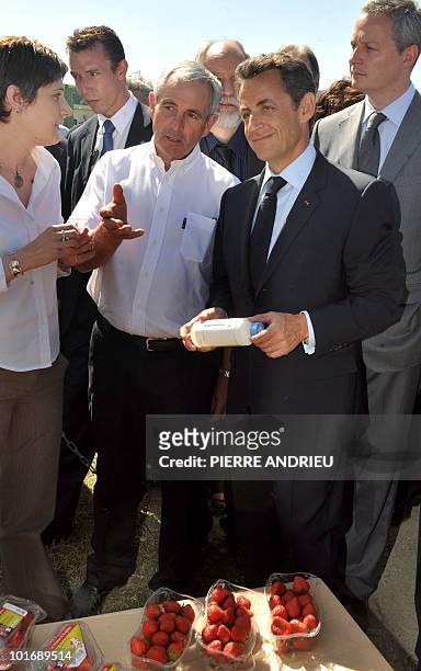 French President Nicolas Sarkozy listens to local strawberry grower Philippe Blouin , on May 21, 2010 in Bouglon, southwestern France, during his...