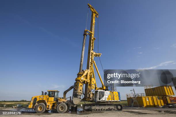 An excavator operates beside a pile driver during ongoing repair work on the A20 Autobahn near Tribsees, Germany, on Wednesday, Aug. 1, 2018. While...