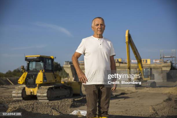 Hartmut Kolschewski, mayor of Lindholz, poses for a photograph by construction machinery during ongoing repair work on the A20 Autobahn near...