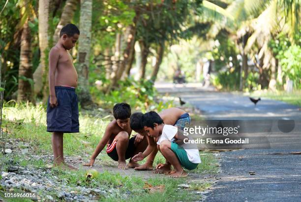 Boys play marbles on the roadside after school on August 15, 2018 in Funafuti, Tuvalu. There are two primary schools on the main island of Funafuti...