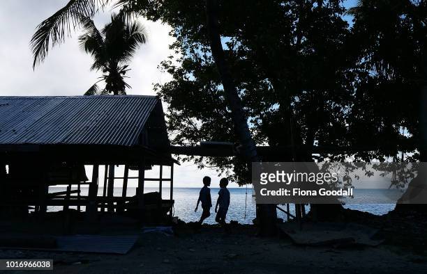 Children play next to a house on the shores of the lagoon on August 15, 2018 in Funafuti, Tuvalu. The small South Pacific island nation of Tuvalu is...