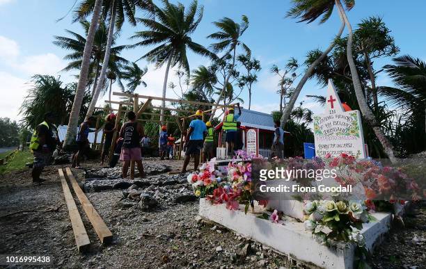 Men erect a temporary shelter for a funeral on August 15, 2018 in Funafuti, Tuvalu. The graves of the dead are adorned and in many cases, given pride...