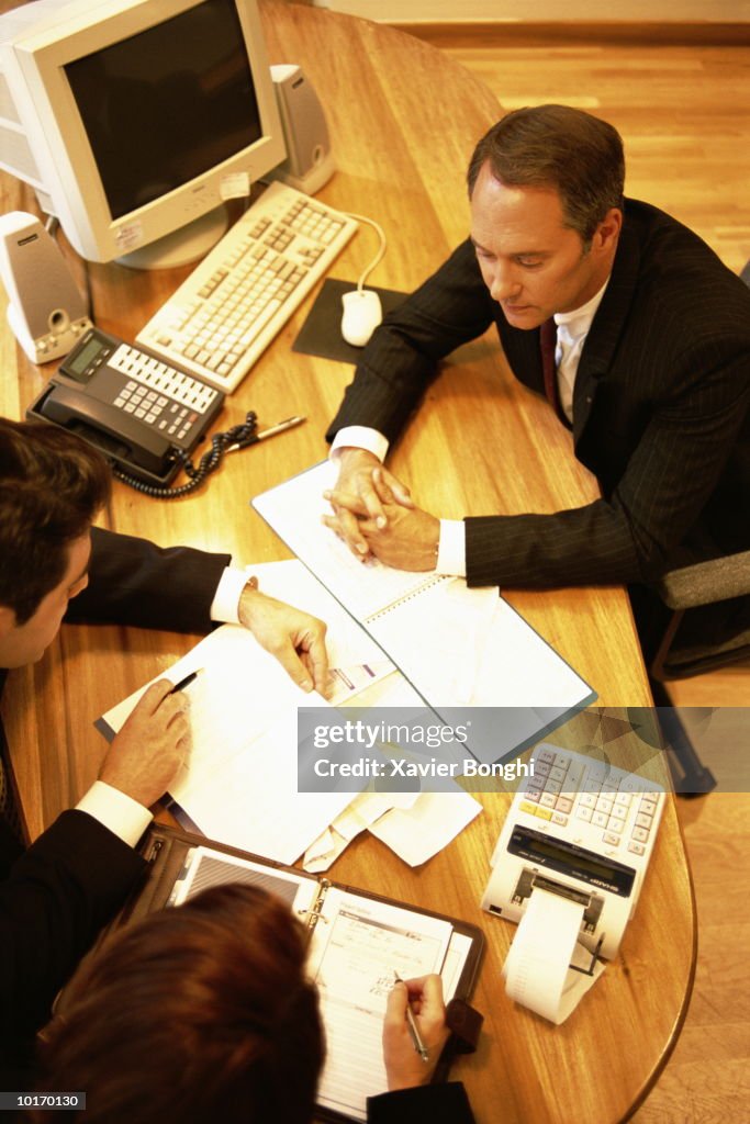 BUSINESSMAN IN OFFICE WITH CLIENTS