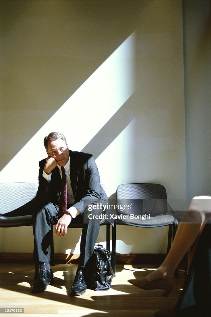 BUSINESSMAN IN OFFICE WAITING AREA