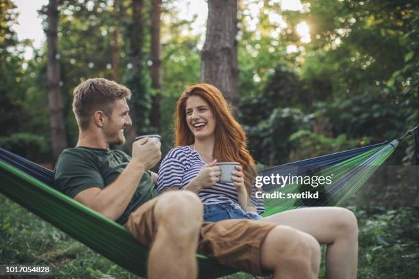 young couple enjoy in hammock - couple camping stock pictures, royalty-free photos & images