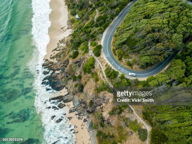 rocky outcrop into ocean with road - new south wales stockfoto's en -beelden
