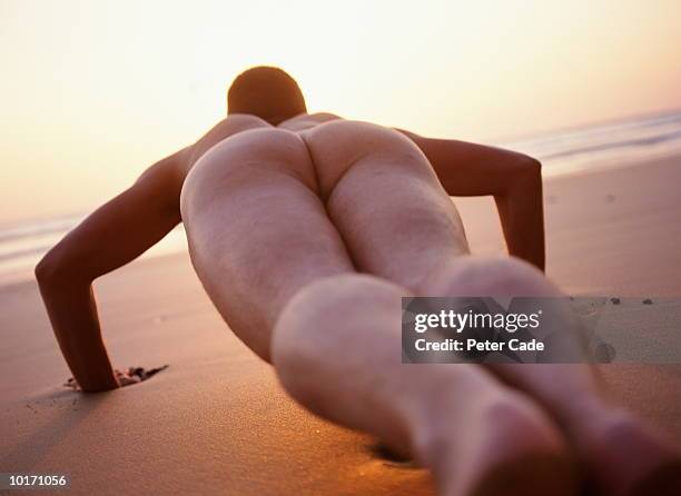 naked man exercising, watergate bay, sunset - male buttocks stockfoto's en -beelden
