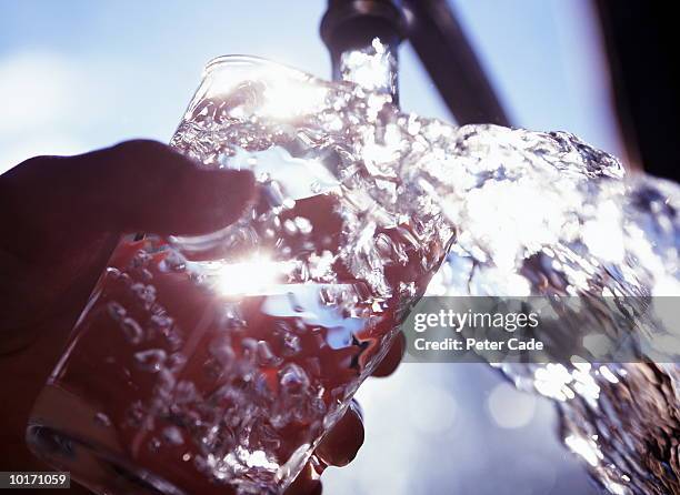 filling glass with water - hand glasses stockfoto's en -beelden