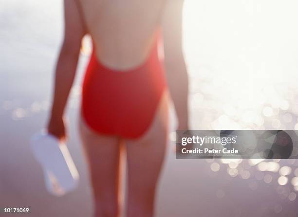 young woman in red swimsuit on beach - eendelig zwempak stockfoto's en -beelden