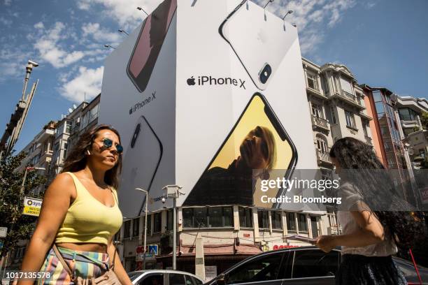 Pedestrians pass an advertisement for Apple Inc. IPhone X smartphones at a highway intersection in the Nisantasi district of Istanbul, Turkey, on...