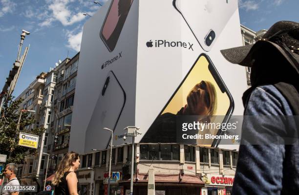 Pedestrians pass an advertisement for Apple Inc. IPhone X smartphones at a highway intersection in the Nisantasi district of Istanbul, Turkey, on...