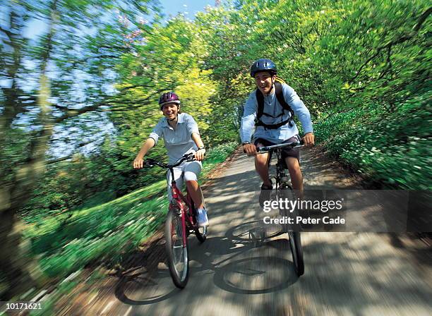 teenage couple cycling on country lane - teenager cycling helmet stock pictures, royalty-free photos & images