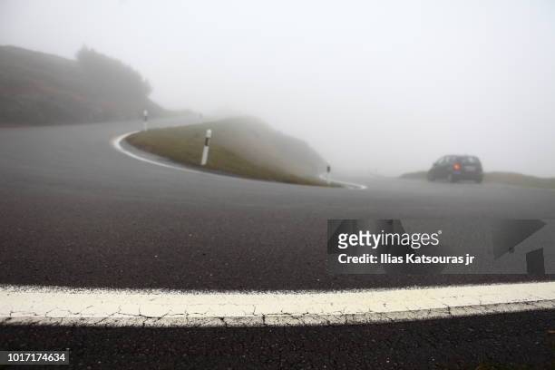 high mountain road in the alps in mist - high and low stockfoto's en -beelden