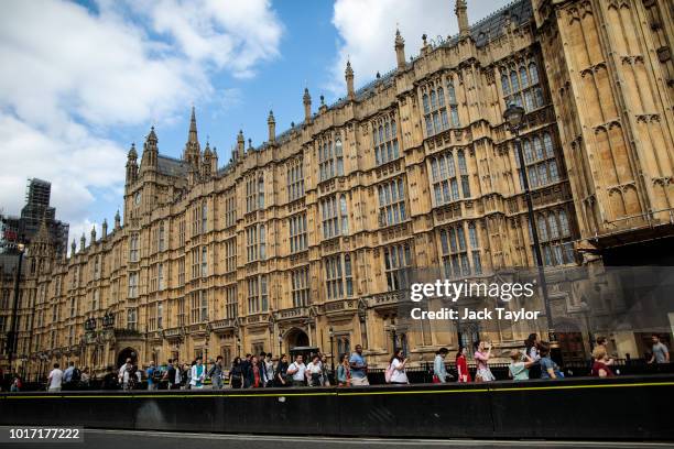 People walk past security barriers outside the Houses of Parliament following yesterday morning's incident, which is being investigated by terror...