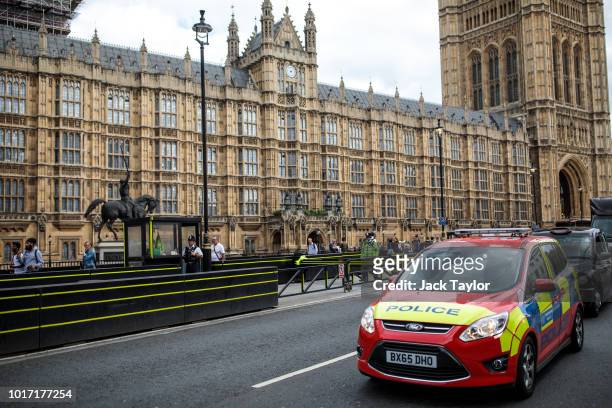 Police car drives past the Houses of Parliament following yesterday morning's incident, which is being investigated by terror police on August 15,...