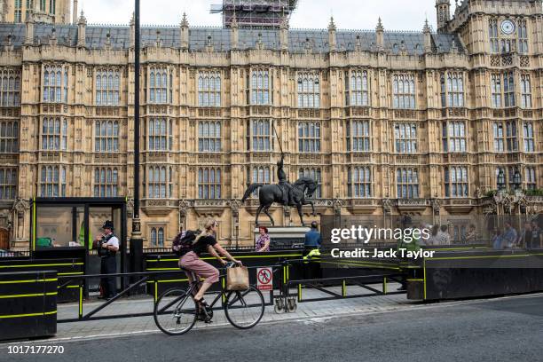 People walk past security barriers outside the Houses of Parliament following yesterday morning's incident, which is being investigated by terror...
