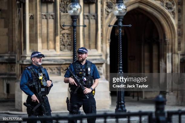 Armed police officers stand behind security barriers outside the Houses of Parliament following yesterday morning's incident, which is being...