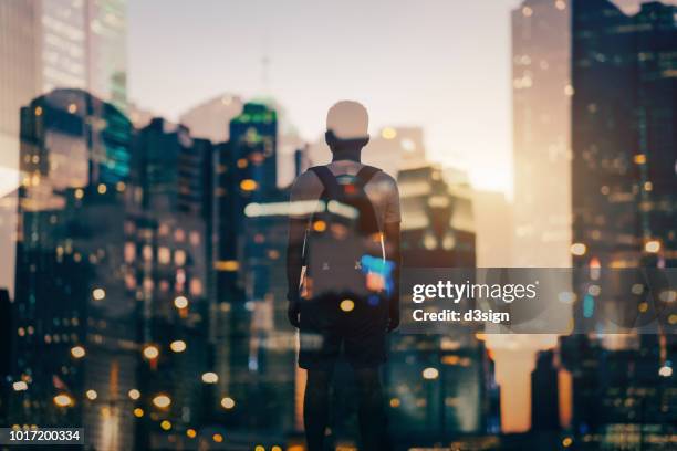 double exposure of urban illuminated cityscape and rear view of man overlooking at city - hong kong advertising stock pictures, royalty-free photos & images