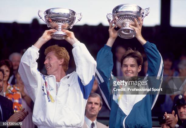 Mark Woodforde and Todd Woodbridge of Australia lift their trophies after defeating Grant Connell of Canada and Patrick Galbraith of the USA in the...