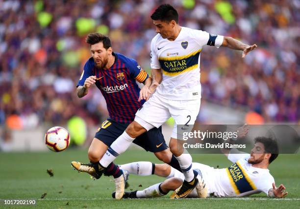 Nahitan Nandez and Paulo Goltz of Boca Juniors challenge Lionel Messi of Barcelona for the ball during the Joan Gamper Trophy between FC Barcelona...