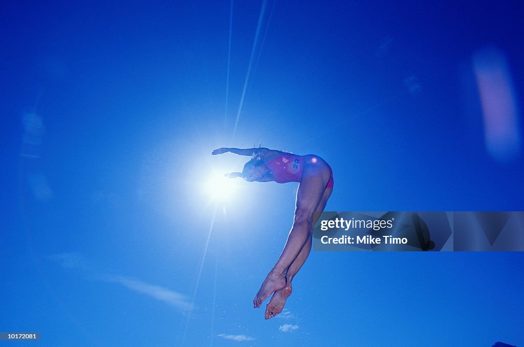 WOMAN IN SWIMSUIT JUMPING INTO WATER