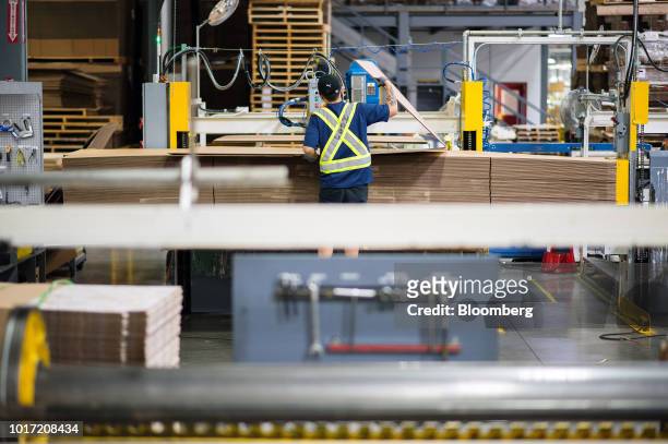 An employee folds cardboard before final assembly at the Great Little Box Co. Manufacturing facility in Vancouver, British Columbia, Canada, on...