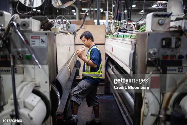 Worker prepares a box assembly machine at the Great Little Box Co. Manufacturing facility in Vancouver, British Columbia, Canada, on Friday, Aug. 10,...