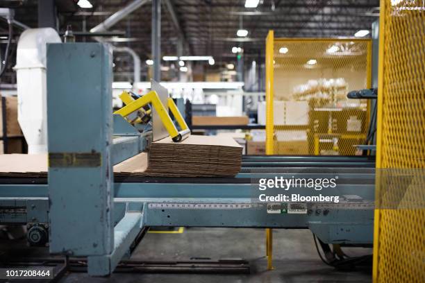 Raw cardboard is fed into a box assembly machine at the Great Little Box Co. Manufacturing facility in Vancouver, British Columbia, Canada, on...