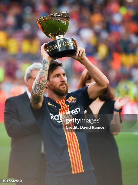 Lionel Messi of FC Barcelona celebrates with the trophy after winning the Joan Gamper Trophy match between FC Barcelona and Boca Juniors at Camp Nou...