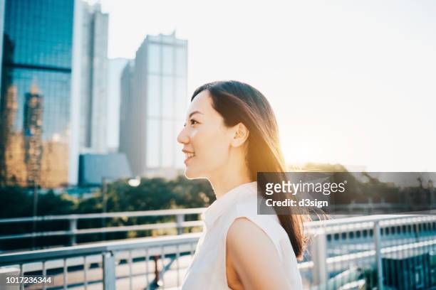 smiling professional young woman against city scene at sunrise - businesswear stock pictures, royalty-free photos & images