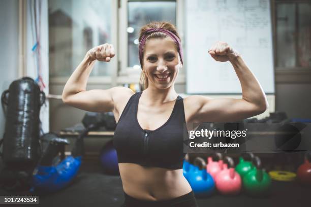 showing muscles in a gym - bodybuilder flexing biceps stock pictures, royalty-free photos & images