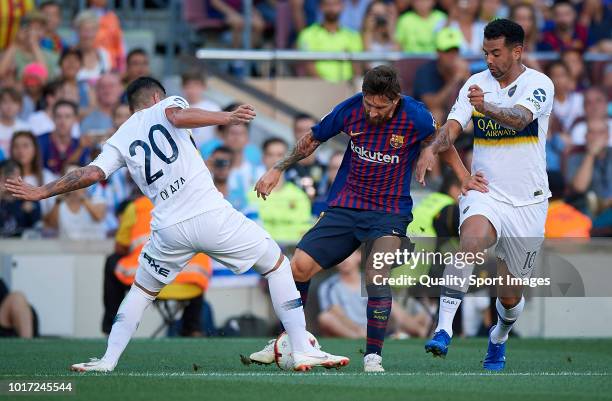 Lionel Messi of Barcelona competes for the ball with Lucas Olaza and Edwin Cardona of Boca Juniors during the Joan Gamper Trophy match between FC...