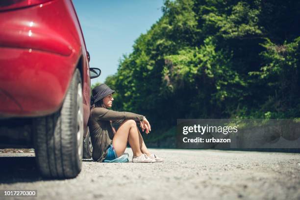 mulher sentada por um carro quebrado para baixo - encalhado - fotografias e filmes do acervo