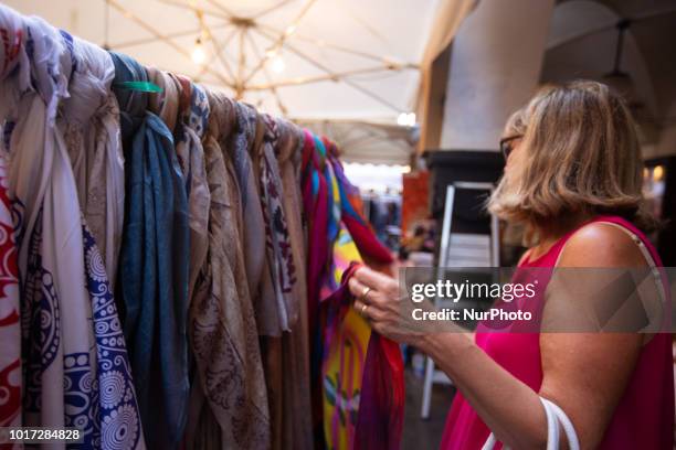 Woman tries some beachrobes. Like every year the 'Ue Sbarassue' was held in the center of Chivari , Ligury, Italy. The shops of the city sell their...