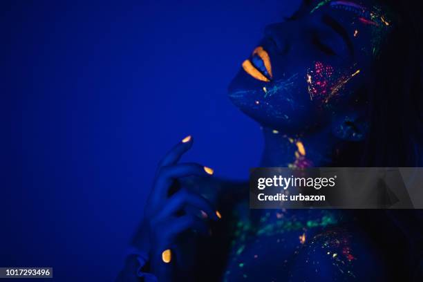 vrouw met fluorescerende make-up - body art stockfoto's en -beelden