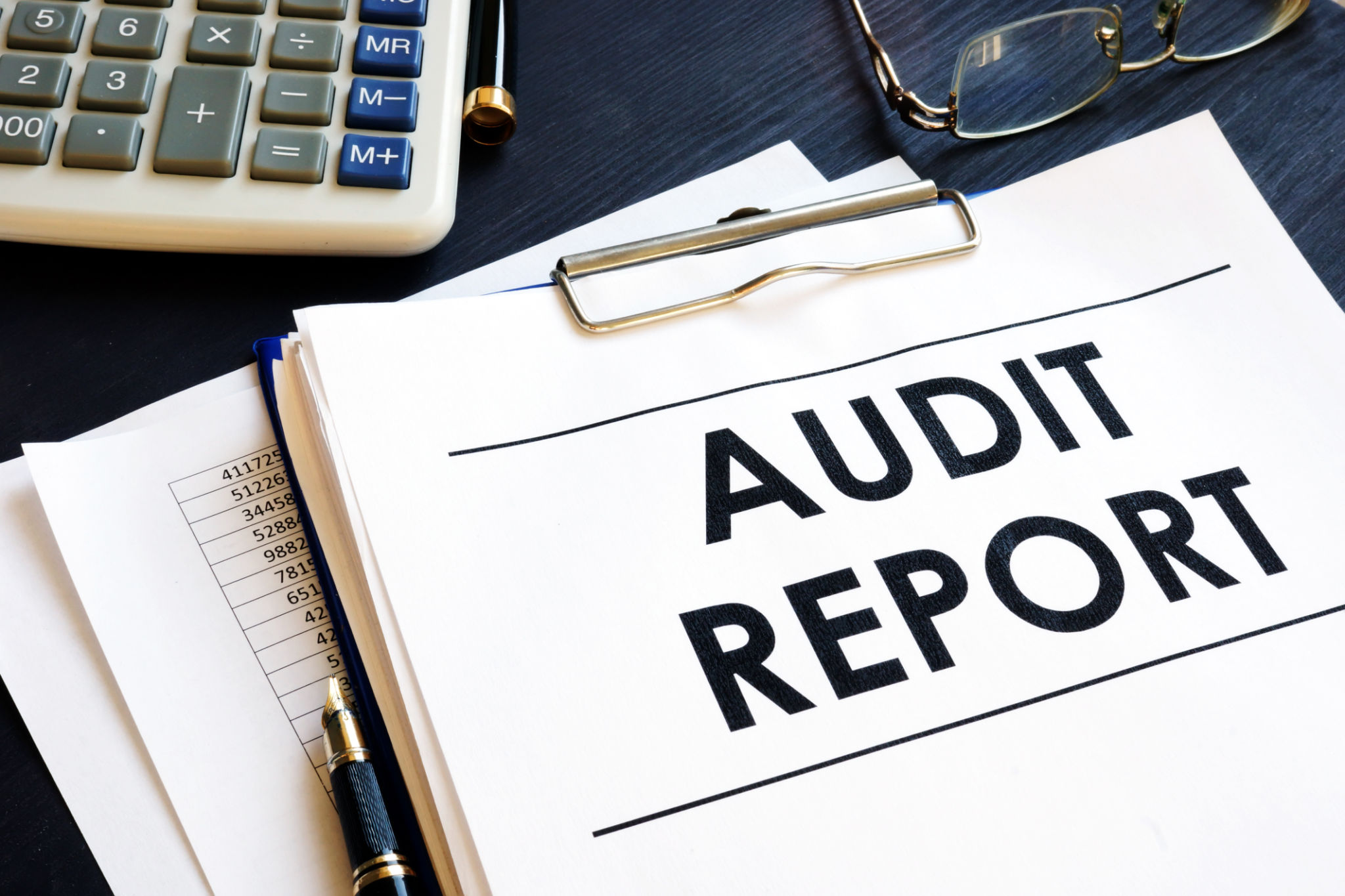 Audit report with business documents in an office. Audit report with business documents in an office.