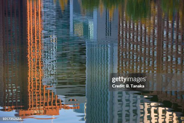 business facade reflections at imperial palace moat in the chiyoda district of central tokyo, japan - moat stock pictures, royalty-free photos & images