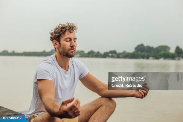 fit mann ausübung von yoga - atemübung stock-fotos und bilder