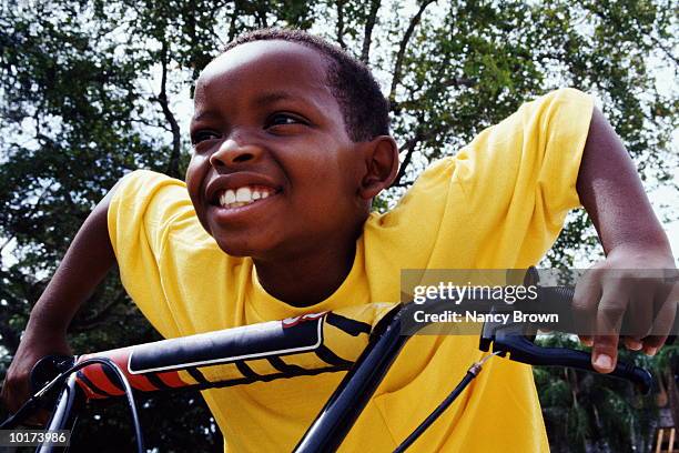 young boy on bike, close-up - boy yellow shirt stock pictures, royalty-free photos & images