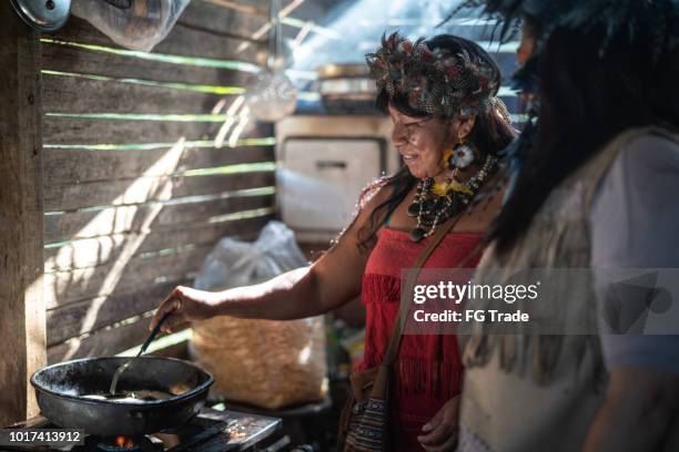 indigenous brazilian women, from guarani ethnicity, cooking "xipa" - brazil village stock pictures, royalty-free photos & images